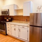 empty white kitchen with stainless steel appliances
