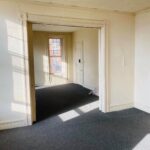 empty rooms with white walls and dark grey carpet