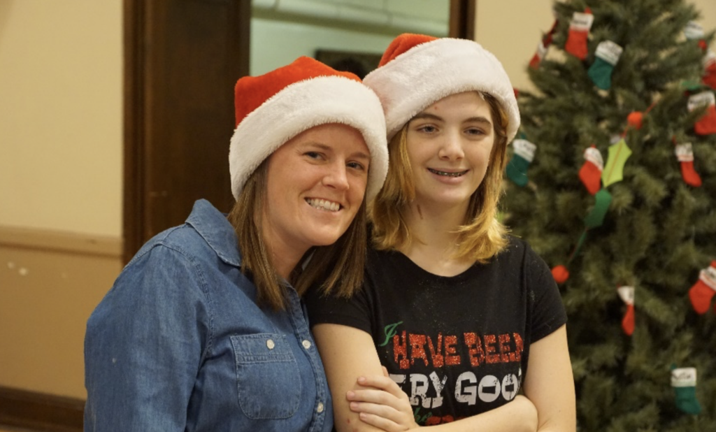 Two women with Santa hats on smiling